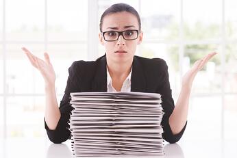 Business_Woman_Stacks_Of_Paper_Arms_Up.jpg