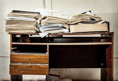 Desk covered with paper documents.